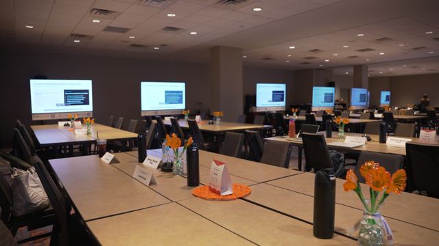 Build tables set with orange flowers before doors open